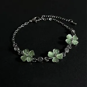 Close-up of elegant green cat eye stone clover bracelet with sparkling crystal accents