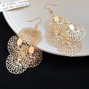 Close-up of gold hollow-out lace multi-layer drop earrings with intricate details.