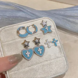 Vista dei dettagli di orecchini d'argento con zirconi blu e motivi a cuore e stella chic