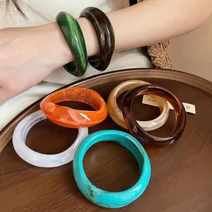 Irregular geometric acrylic marbled bangles with colorful artistic patterns.