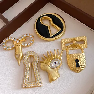 Detailed close-up showing vintage gold-tone brooches with keyhole, eye, and lock designs