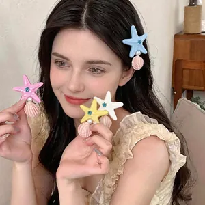 Stylish starfish and pearl duckbill hair clips worn by a model for a beach vacation look.