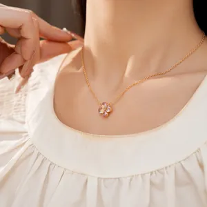 Detalle de un elegante collar de oro con un colgante de flor de circón rosa en una modelo