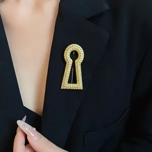 Macro view of vintage gold keyhole brooch with sparkling stones on a black blazer jacket