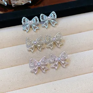 Elegant silver-needle hollow bow stud earrings with dainty pearls in multiple colors