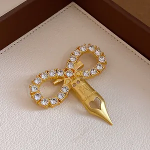 Detailed view of a vintage infinity brooch with zircons and a heart-shaped pen nib