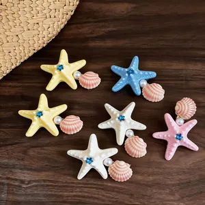 Detailed view of colorful starfish and seashell hair clips featuring pearls and rhinestones.