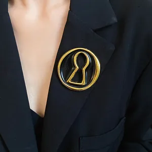 Elegant vintage keyhole brooch with gold-tone finish pinned on a black blazer lapel