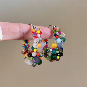 Close-up of vibrant dopamine style colorful beaded hoop earrings with silver pins