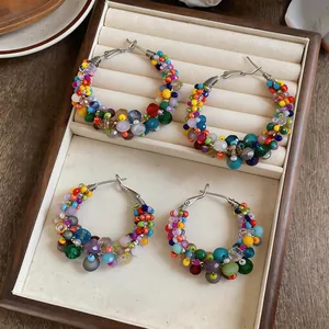 Detail showing vibrant glass beads and irregular patterns on colorful hoop earrings