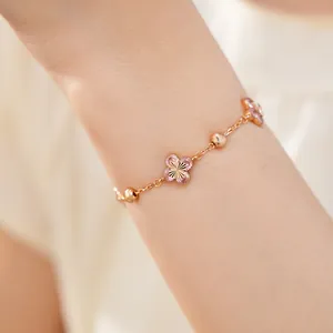 Vista detallada de una elegante pulsera con flores de circón rosa y cadena de oro