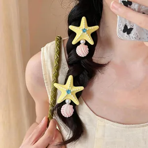 Yellow starfish hair clip with pink shell and pearl detail for a summer beach vacation style