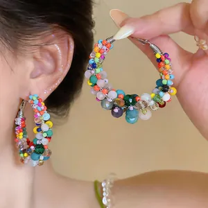 Detail shot of colorful dopamine-style beaded hoop earrings with silver needles jewelry