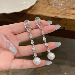 Close-up of elegant zircon tassel ear clips with white pearl drops for non-pierced ears