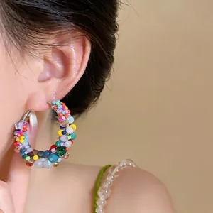 Close-up of vibrant multicolored beaded hoop earrings worn on ear