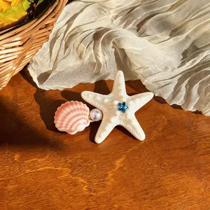 Close-up of starfish hair clip with seashell and pearl detail for beach vacations