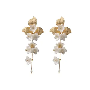 Elegant long floral tassel earrings featuring white blossoms and pearls in a gold finish