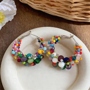 Detail showing the colorful irregular glass beads on these silver needle hoop earrings.