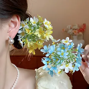 Close-up of fresh fabric flower hair clips in blue and yellow worn by a model