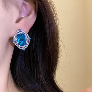 Macro detail of a vintage royal style blue rectangle zircon earring worn on model's ear