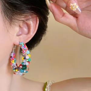 Close-up detail shot of colorful dopamine glass beaded hoop earrings with silver needles