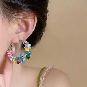 Close-up of colorful beaded hoop earrings with vibrant dopamine-inspired glass beads.