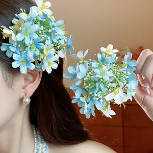 Detail showing elegant light blue fabric flower hair clips worn on a model's head