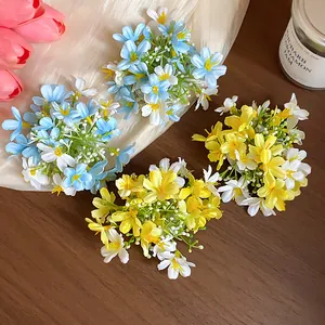 Detailed view of delicate yellow and blue fabric flower hair clips on a wooden surface
