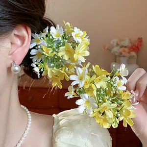 Close-up of vibrant yellow and white fabric flower hair accessories styled on a model