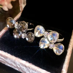 Macro view of two butterfly-shaped rings with sparkling rhinestones in a pink velvet box.