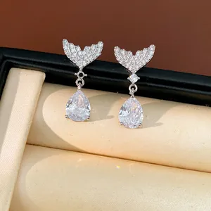 Detailed shot of sparkling fishtail drop earrings with pear-shaped zirconia stones.