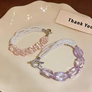 Elegante bracciale di perle multistrato con perle viola irregolari su piatto in ceramica