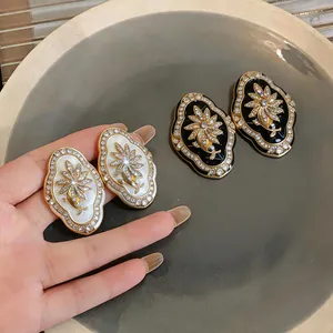 Detail of vintage court style flower stud earrings with rhinestones in black and white
