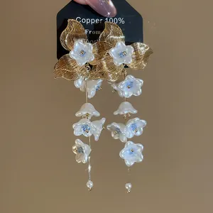 Macro detail view of elegant French floral tassel earrings with white blossoms and pearls