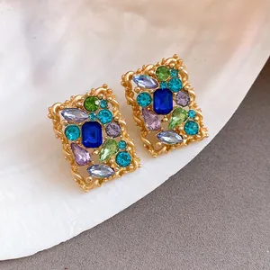 Dettaglio di orecchini a perno vintage rettangolari con cristalli colorati in oro