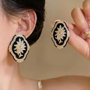 Macro view of vintage court style earrings with sparkling floral rhinestone patterns.