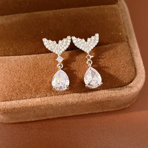 Detail macro shot of silver fishtail stud earrings with sparkling teardrop zirconia