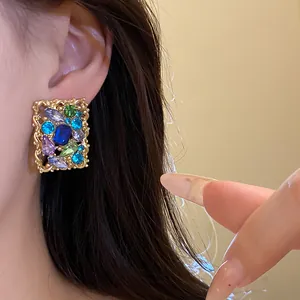 Primo piano di orecchini a perno vintage in oro con strass multicolore brillanti