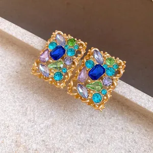 Primo piano di orecchini vintage con intarsio di cristalli colorati e finitura oro