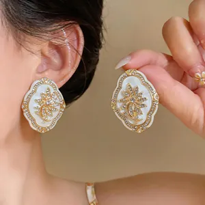 Close-up detail of vintage palace style gold flower earrings with sparkling rhinestones