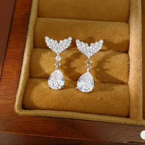 Close-up of elegant silver earrings with fish tail design and teardrop cubic zirconia
