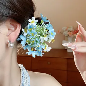 Detailed close-up of light blue and white fabric flower hair clip worn on a side bun