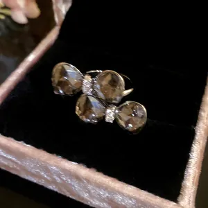 Detailed macro shot of sparkling double bow-tie open ring nestled in a pink velvet jewelry box