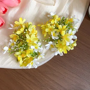 Detailed close-up of yellow and white fabric flower hair clips on soft fabric