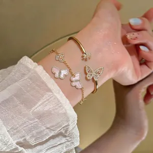 Elegant gold butterfly charm bracelet set with sparkling zircon on a woman's wrist.