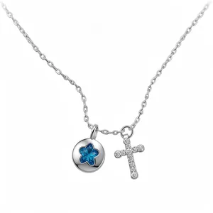 Silver necklace featuring blue star round pendant and crystal paved cross charm on white background