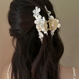Vue détaillée d'une pince à cheveux vintage avec fleurs en dentelle et perle