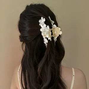 Détail d'une pince à cheveux vintage à fleurs en dentelle avec perles sur cheveux