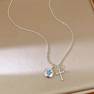 Detailed view of silver bead chain necklace featuring a star disc and cross charm