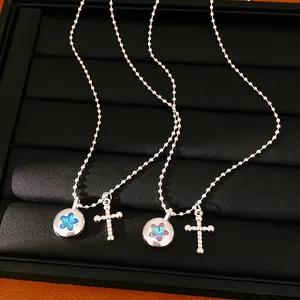Detail view of silver-tone necklaces with star pendants and cross charms on a display tray.
